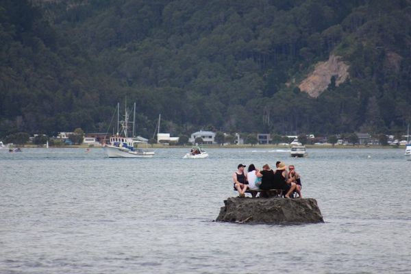 Groep mannen drinkend op een zelfgemaakt eiland in Nieuw-Zeeland om een alcoholverbod te omzeilen.